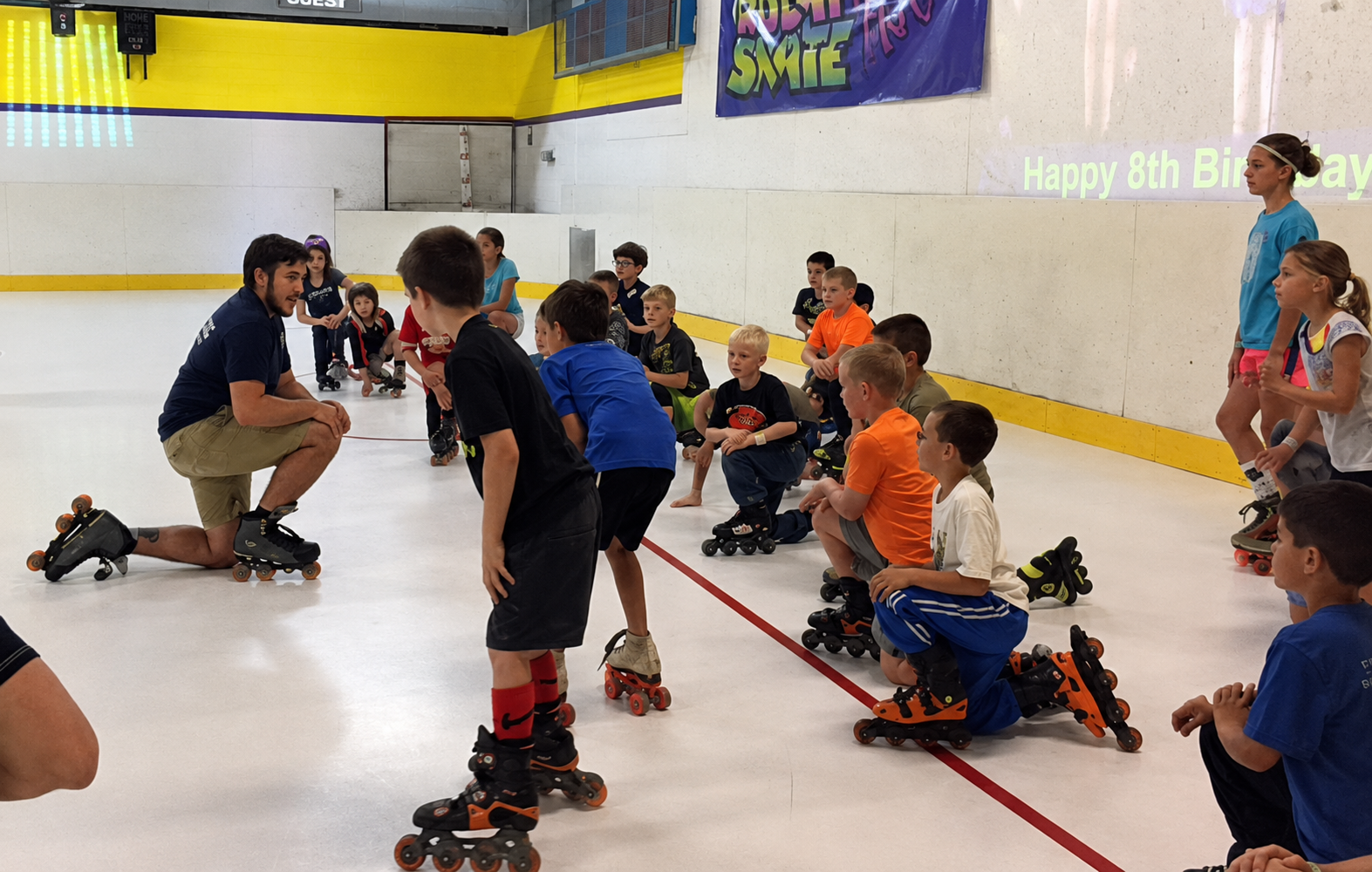 Kids at indoor roller rink with instructor